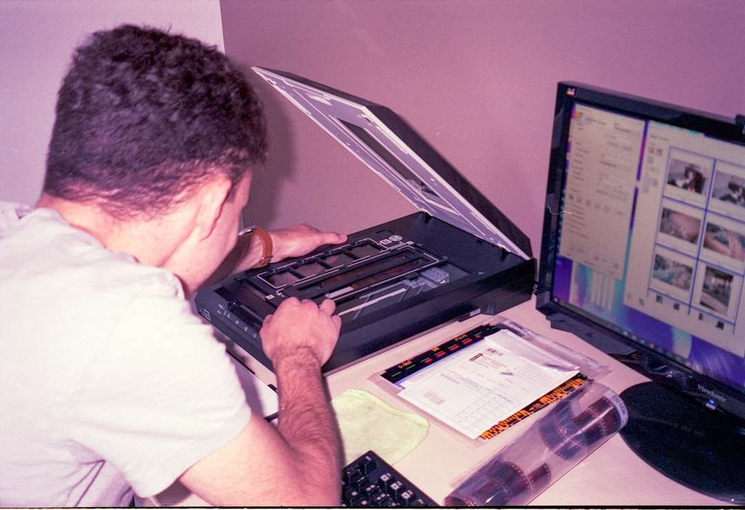 a man sitting at a desk using a laptop computer pest control software dashboard compliance report screen technician mobile app pest control