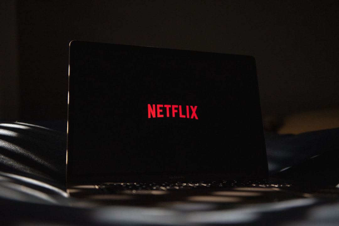 a laptop computer sitting on top of a bed wifi router streaming problem netflix error