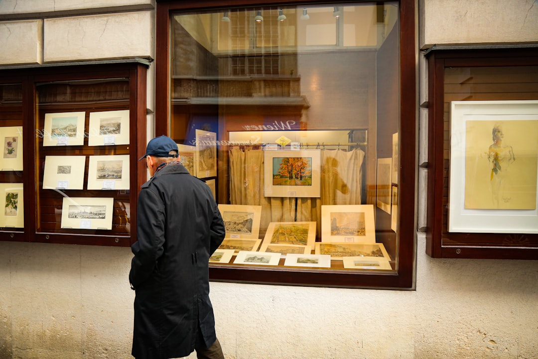a man standing in front of a store window bidding online auction website people bidding