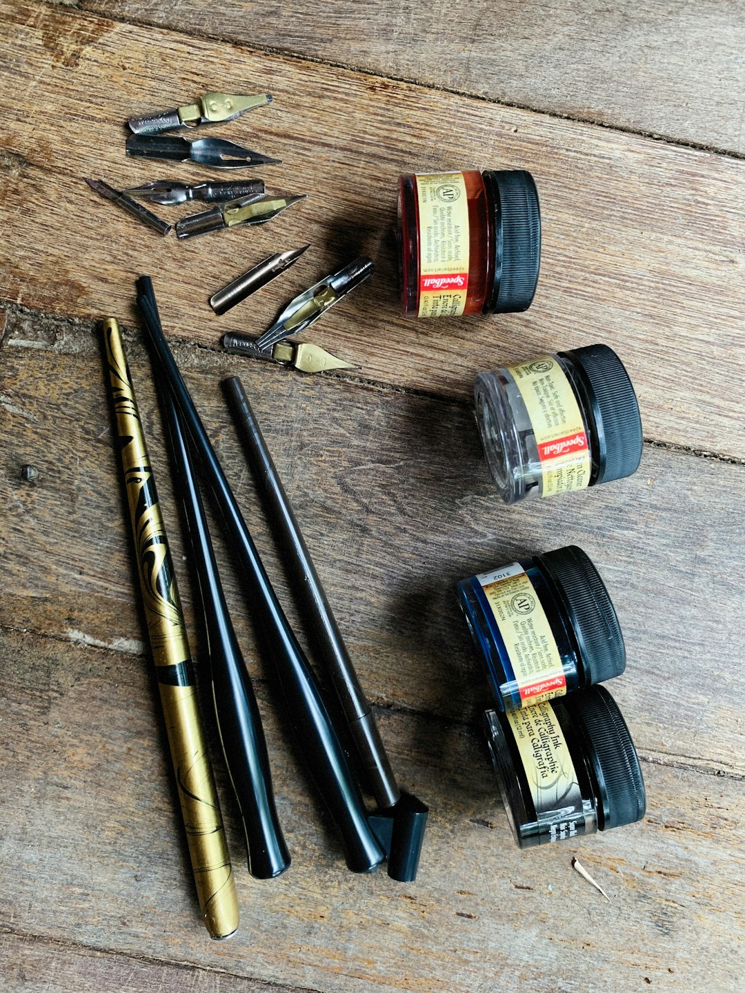 a wooden table topped with different types of pens and ink dab rig concentrate vape pen wax tool kit