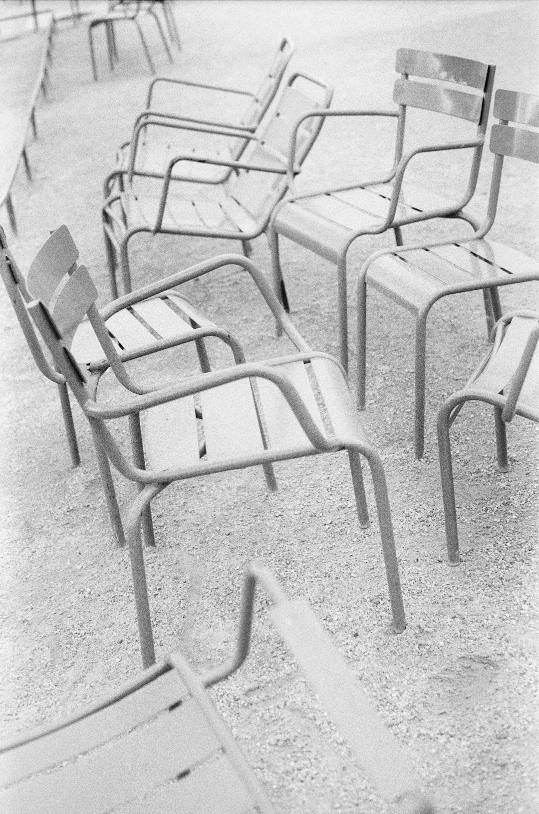 black and white photograph of a row of empty chairs conversation layout chairs room