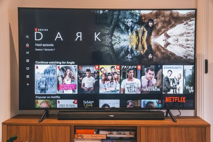 black flat screen tv turned on displaying man in black suit apple tv, chromecast, roku, amazon fire tv, privacy comparison