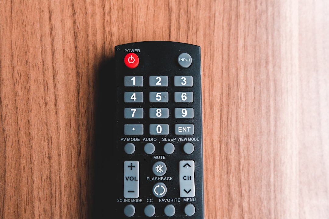 Xfinity Remote Full Reset & Re-Pair: When to Start Over and How 1 black remote control on brown wooden table xr15 remote xfinity buttons close up remote control
