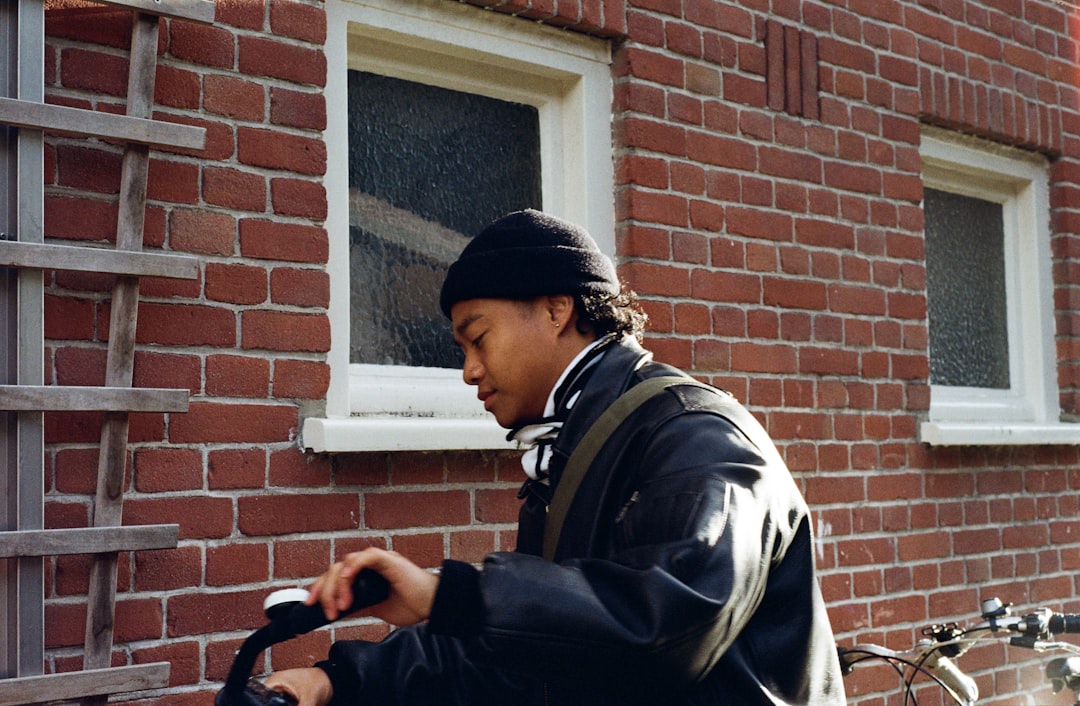 man in black beanie and jacket with bicycle code enforcement officer tablet property inspection city neighborhood