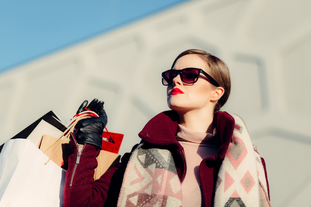 shallow focus photography of woman holding shopping bags during day coupons promotion shopping discounts