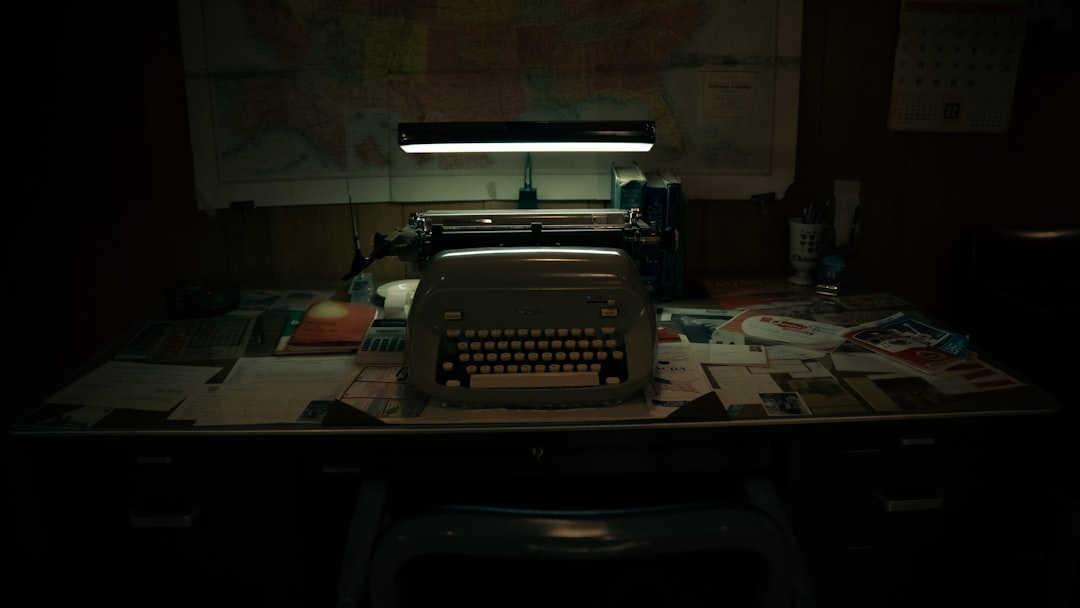 typewriter sits on a cluttered desk in dim lighting indie horror set scriptwriter director with laptop