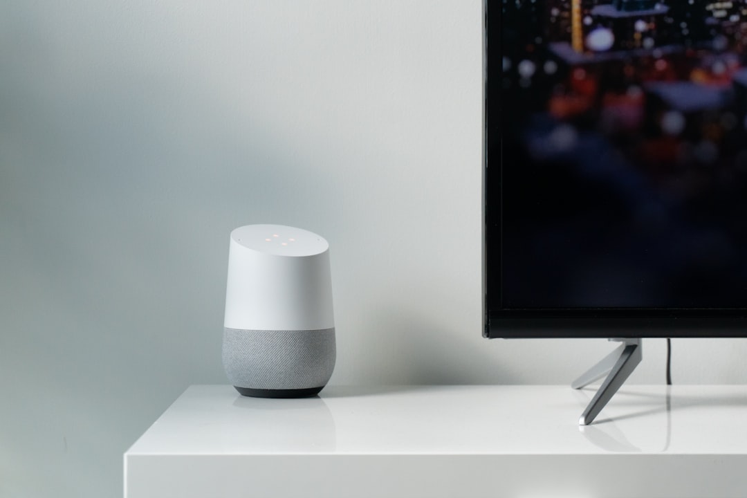 white and gray google smart speaker beside black flat screen tv smart tv alexa google assistant home automation