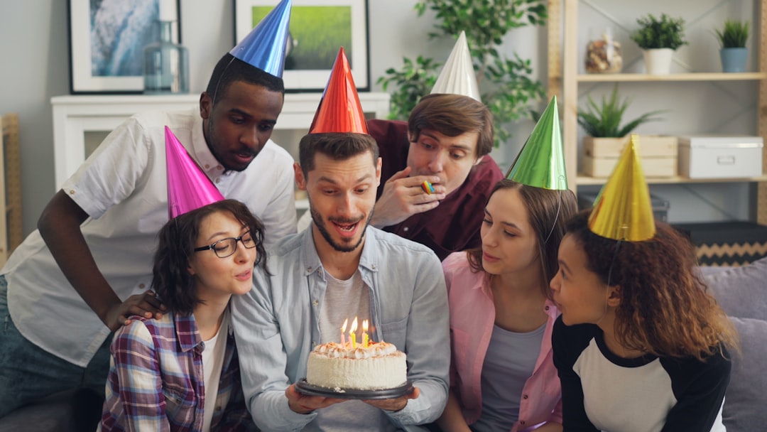 How Employee Spotlight Programs Are Boosting Morale and Engagement in U.S. Workplaces 1 a group of people standing around a cake with candles on it employee recognition office celebration workplace culture