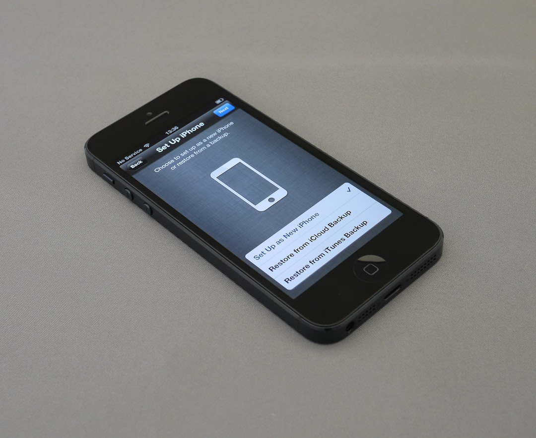 black iphone close up photography person downloading photos from phone photo backup screen mobile gallery interface