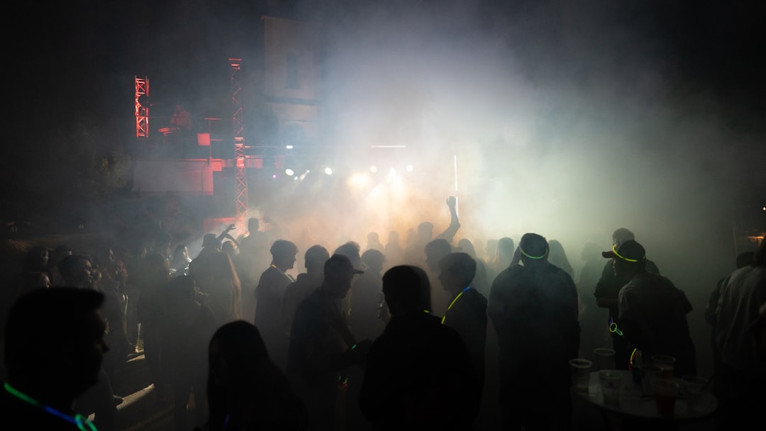 a group of people standing around in the dark drugs party club nightlife