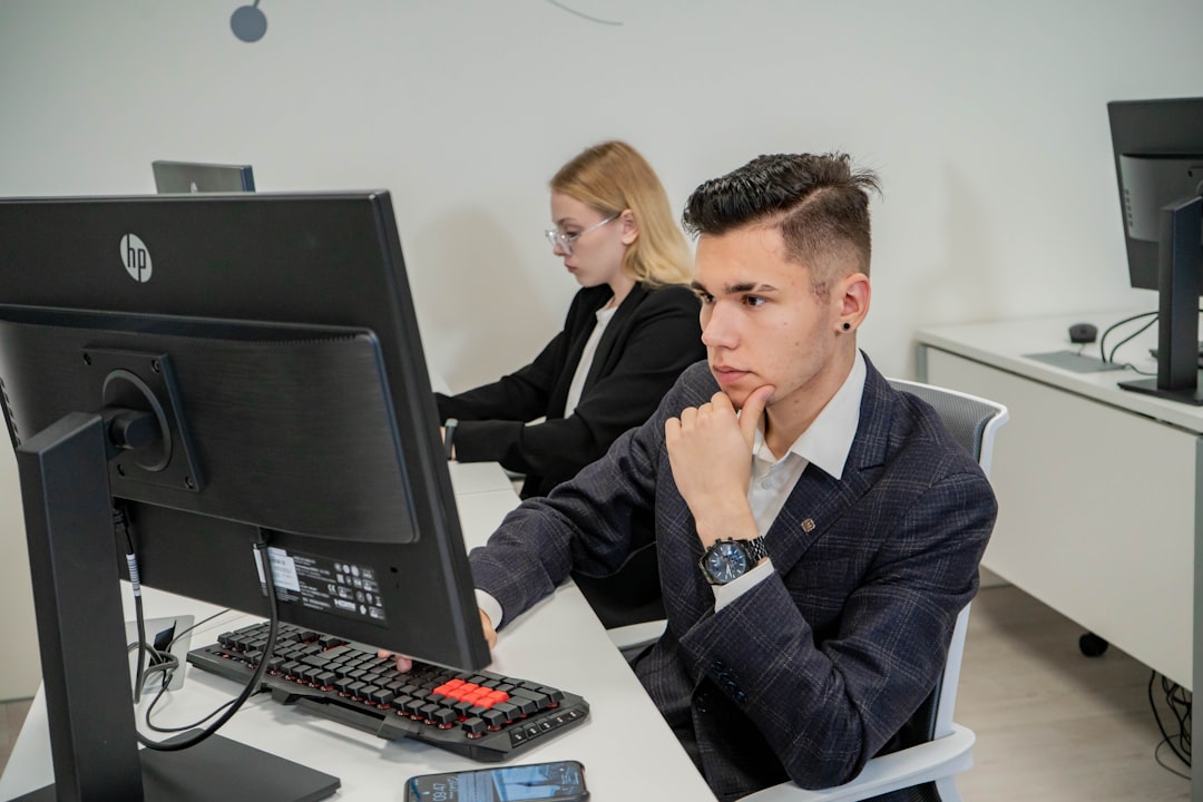 a man sitting at a desk in front of a computer corporate security training business professionals learning cyber defense teamwork