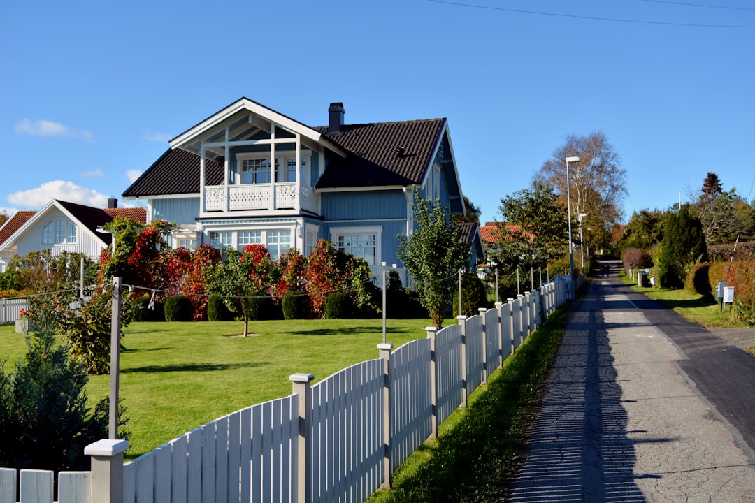 a house with a white picket fence in front of it home buying neighborhood view happy family inspecting house