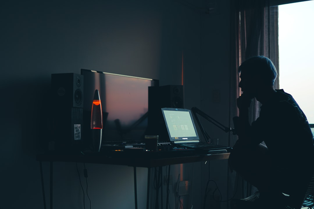a man sitting in front of a computer in a dark room erp integration scalability api connection