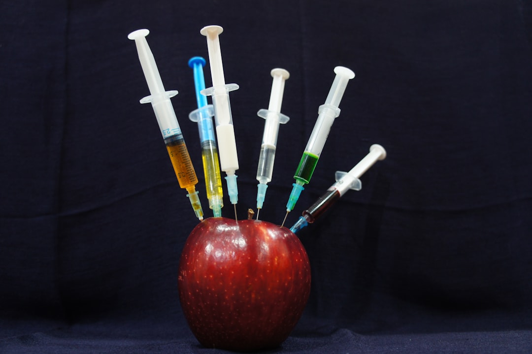 Why Everyone Is Talking About Neuralink 1 apple fruit with plastic syringes brain implant neural interface futuristic medicine