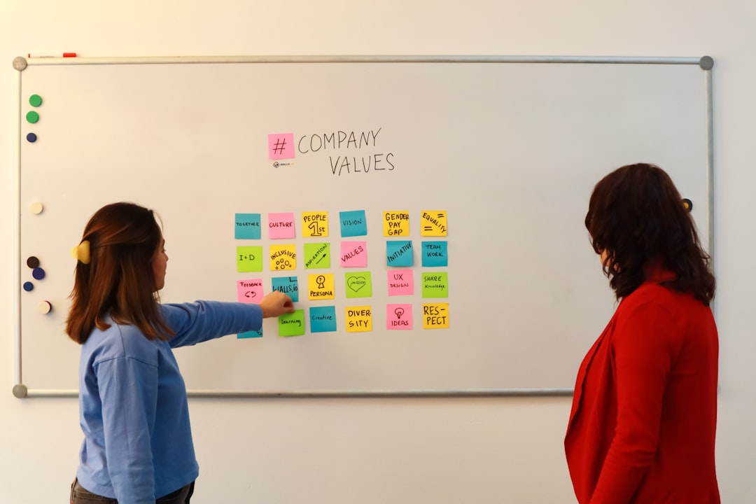 Can I use stock photos in advertising campaigns? 1 two women standing in front of a white board with sticky notes on it marketing team stock images brainstorming