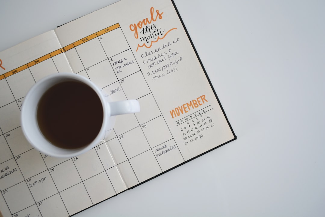 How can I utilize tools for Instagram content calendar planning? 1 white ceramic mug with coffee on top of a planner instagram calendar planner app social media management