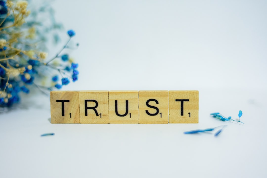 The Power of Response: How to Write Review Replies That Build Trust and Loyalty 2 a wooden block that says trust surrounded by blue flowers review reply business communication trust building