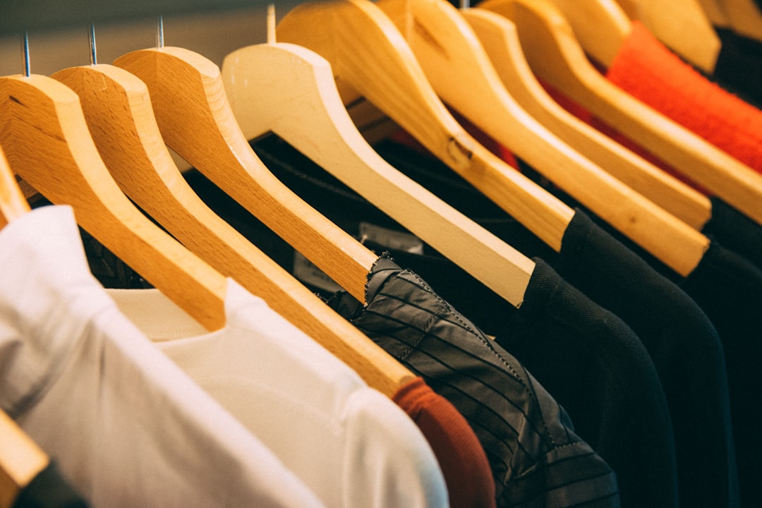 The top online marketplaces in the UK in 2025 3 clothes hanged on brown wooden hanger vinted app clothing resale eco fashion