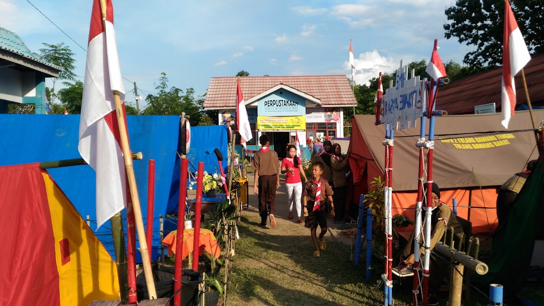 How can local businesses effectively target and reach their local audience? 2 people walking near stores during daytime community event small business tent neighborhood fair