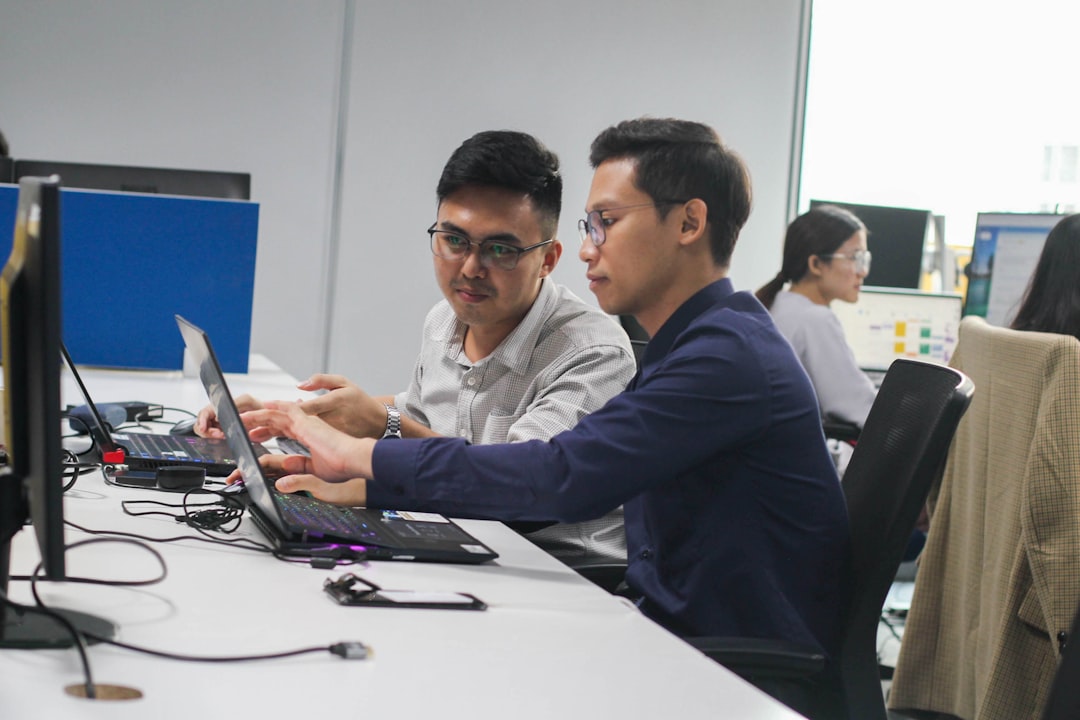 Apex Traffic vs ClickSEO: Which One Is Right for Your Business? 2 two men sitting at a desk looking at a laptop technical seo marketing analysis digital dashboard