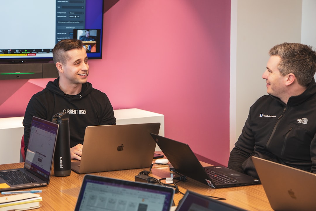 Microsoft Building 40: Inside One of Redmond’s Key Campuses 2 a couple of men sitting at a table with laptops microsoft teams office workspace product demo