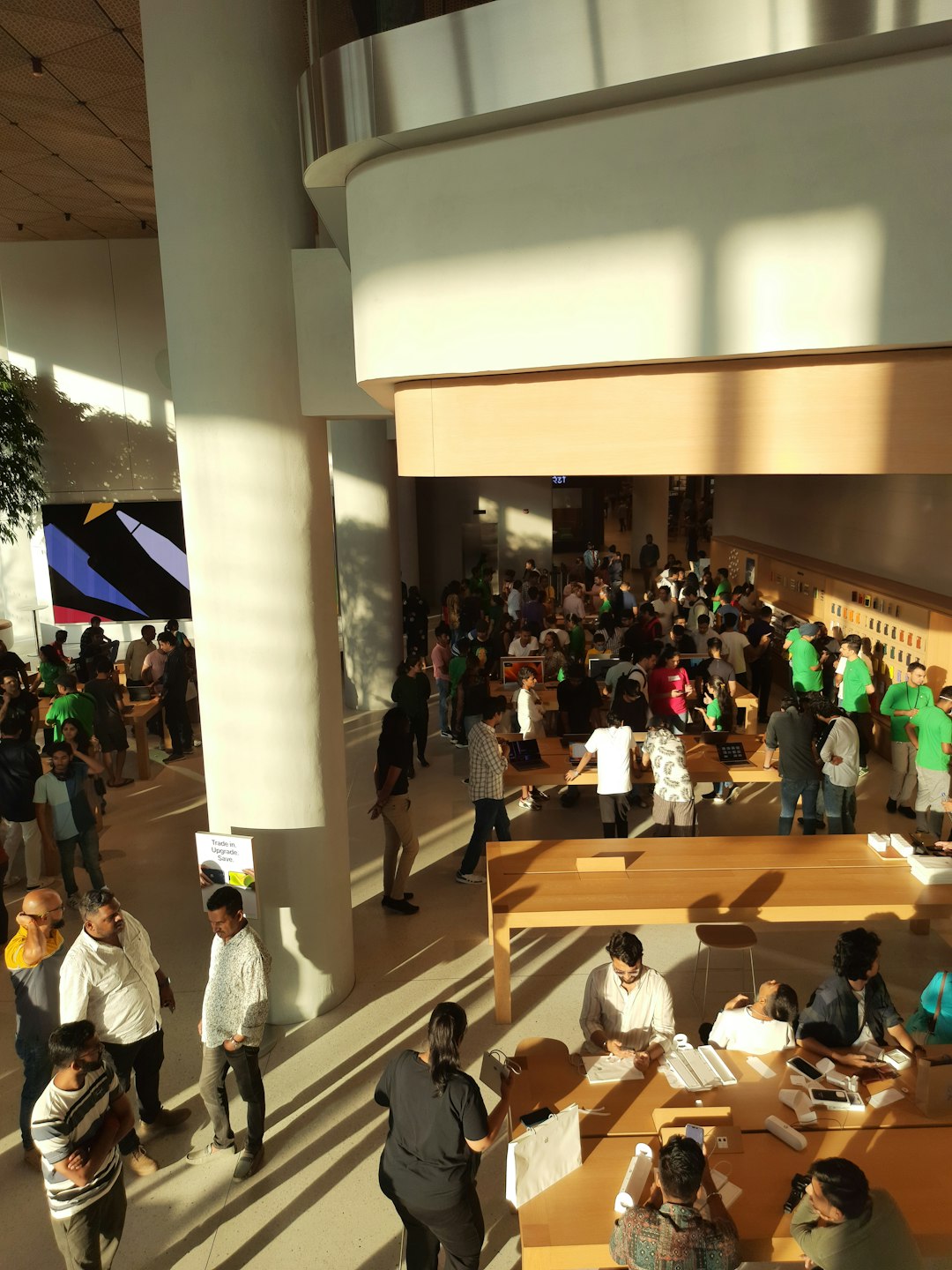 a large group of people standing in a building microsoft campus tech workers modern interior