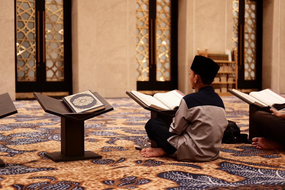 a man sitting on the floor reading a book scholarly conference history books islamic philosophy