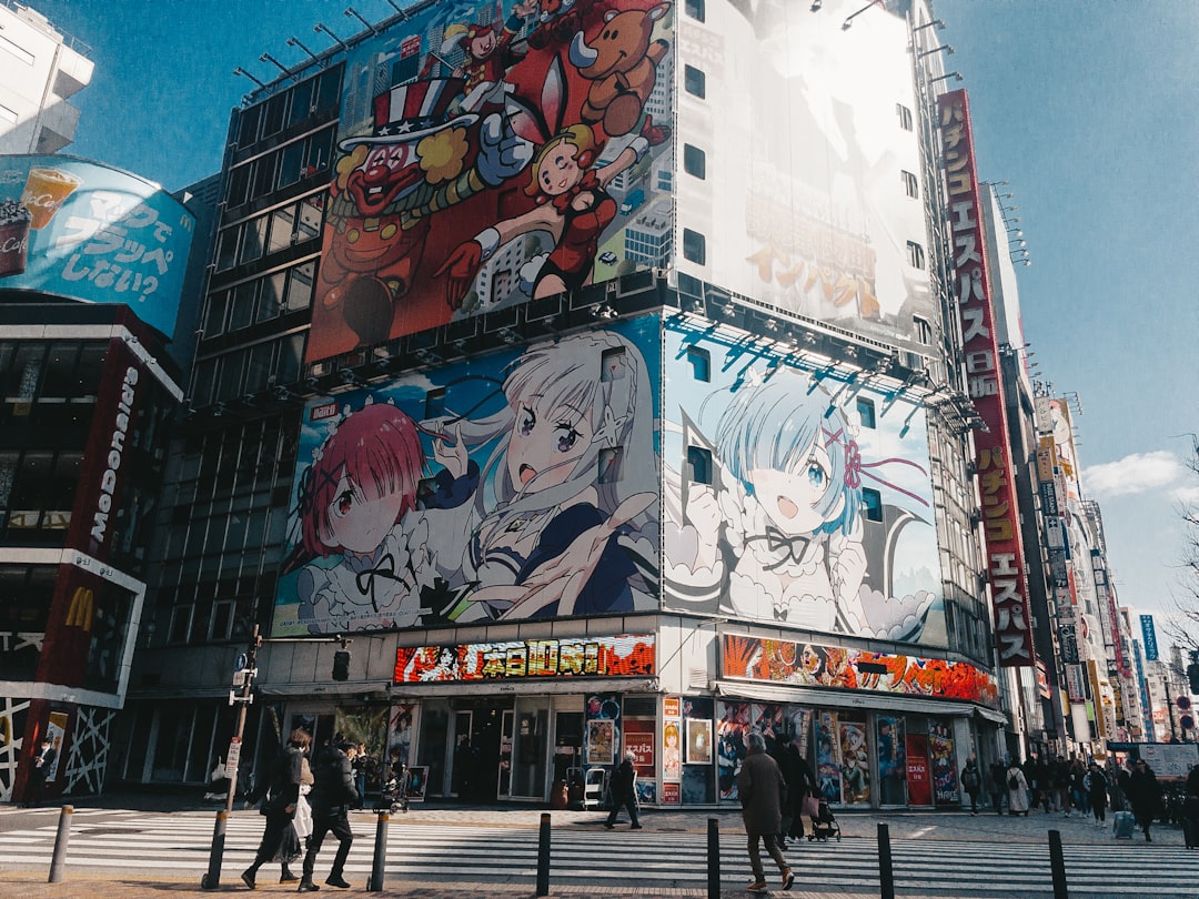 building with large anime billboards in a city anime production creator revenue animation studio