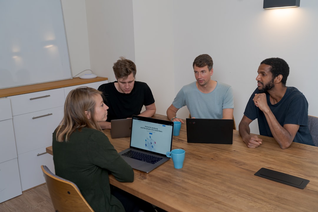 group of people sitting on chair in front of brown wooden table microsoft teams office workspace product demo