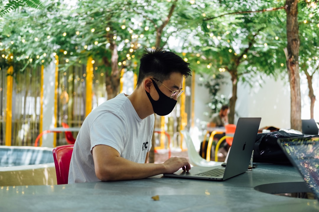 man in white crew neck t shirt wearing black sunglasses using laptop computer antivirus settings firewall itunes connection