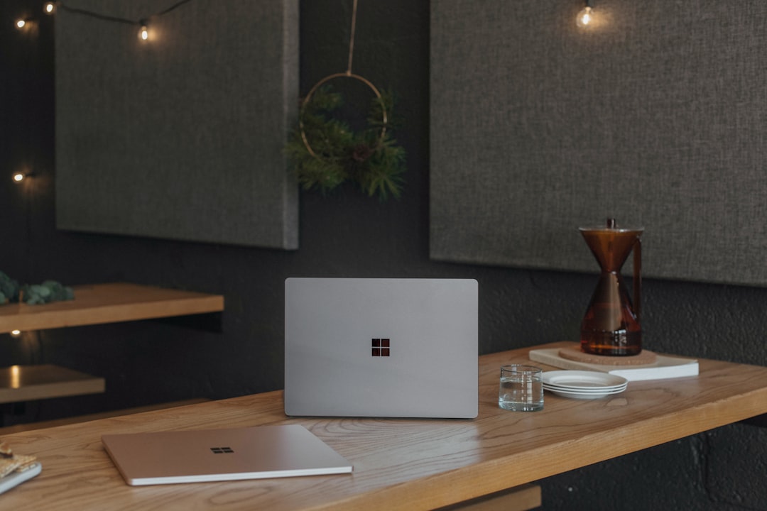 surface laptops on a table at work with christmas lights in the background microsoft teams office workspace product demo