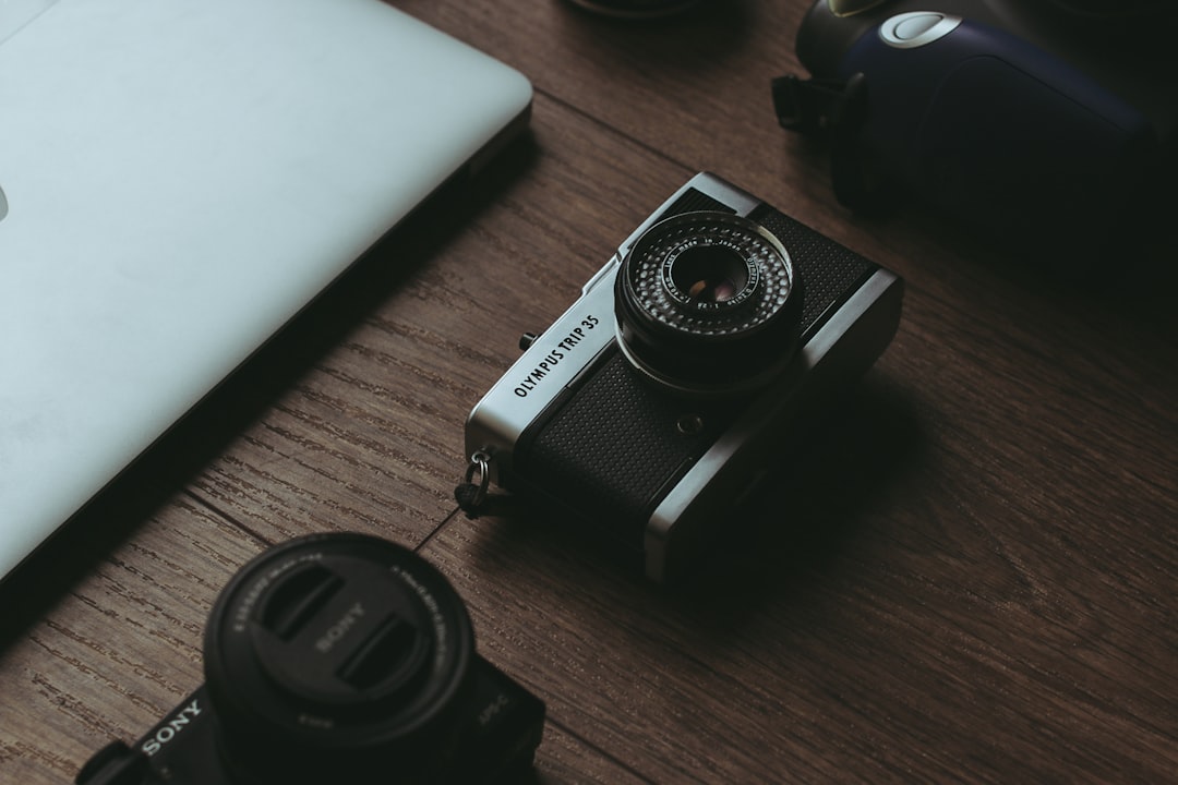 a laptop computer sitting on top of a wooden table photographer at computer editing photos online tools 1