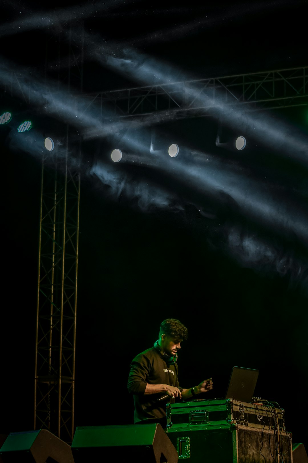 a man on a stage with a laptop dj event big speaker concert sound