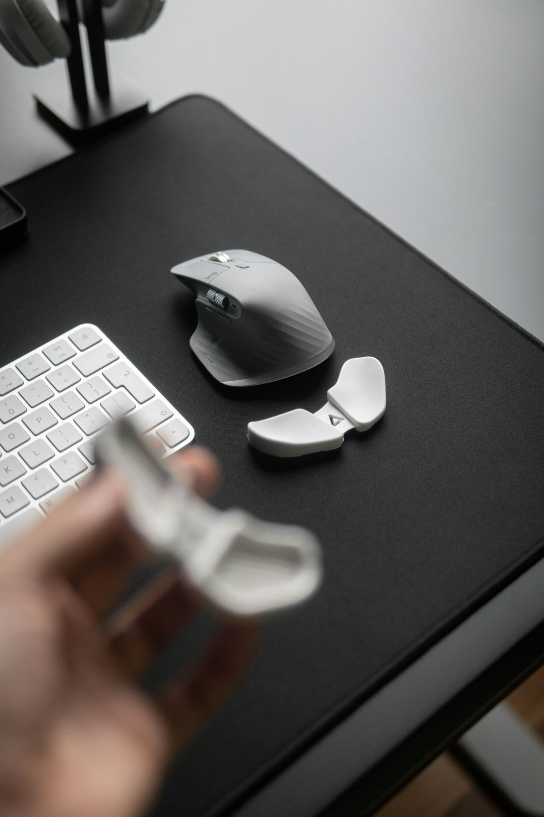 How to Connect Your Magic Mouse to a Mac: Simple Step-by-Step Instructions for Beginners 2 a person is holding a mouse near a keyboard and a mouse pad magic mouse gesture settings mac mouse settings