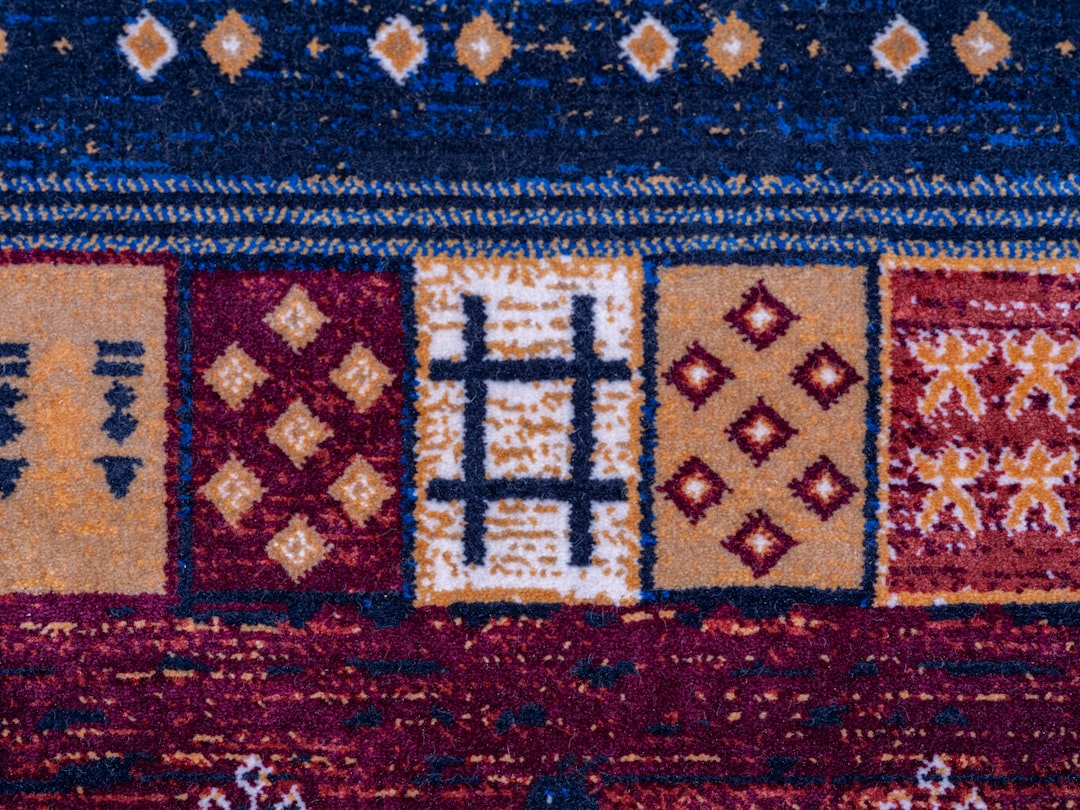 close up of a colorful patterned carpet with geometric designs aged berber rug warm tones bohemian interior