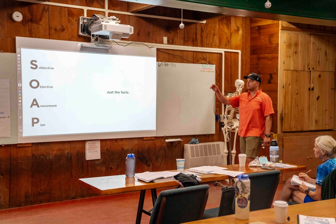 man presents information on a whiteboard to an audience security training employee workshop cyber awareness