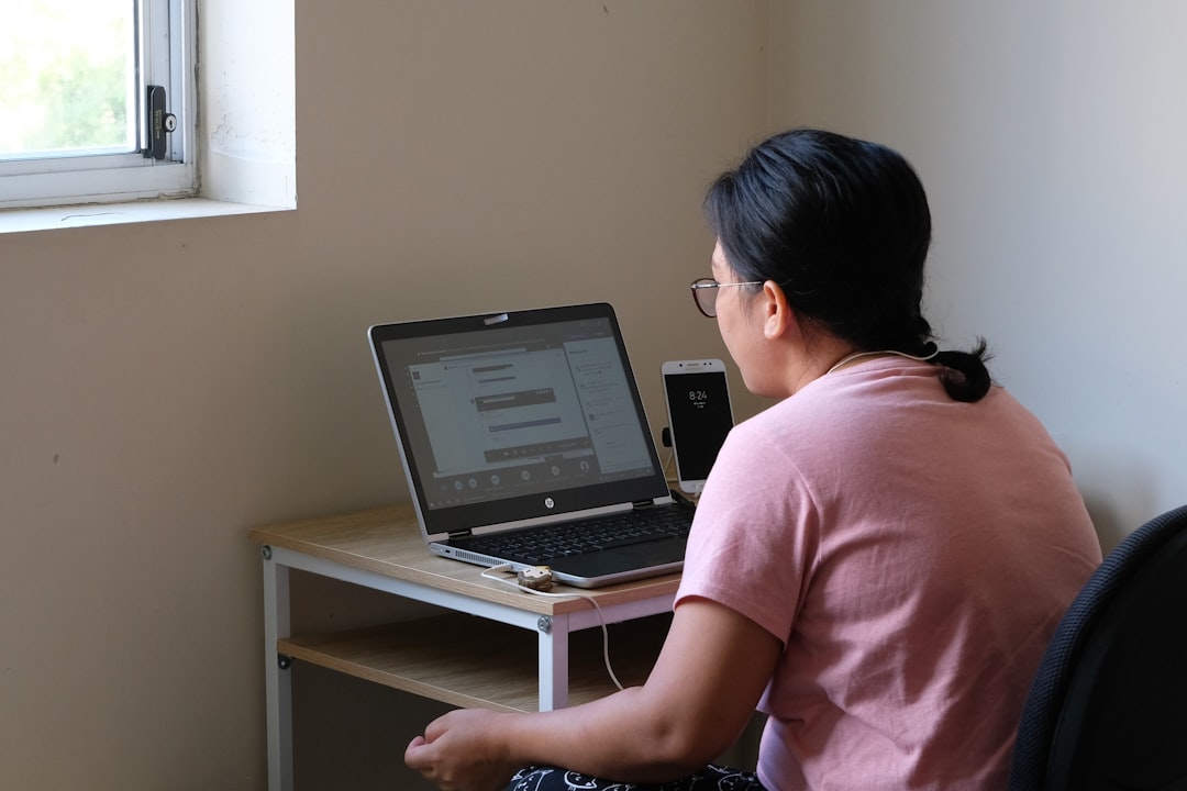 woman in pink t shirt using laptop computer ux testing feedback laptop person working