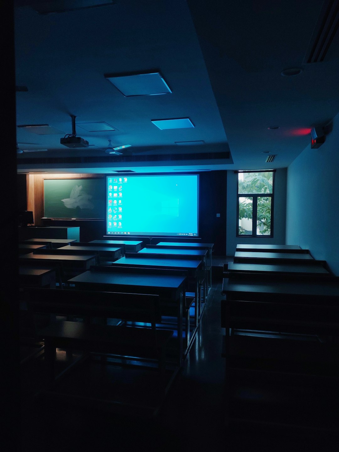 How to Use Gmail Filters to Manage Google Classroom Emails 2 a dark room with tables and chairs and a projector screen google classroom email subject filter