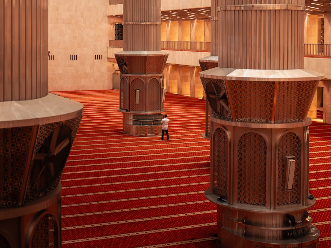 a lone man stands in a large hall with red carpet minecraft palace decorated interior creative build chandelier 1