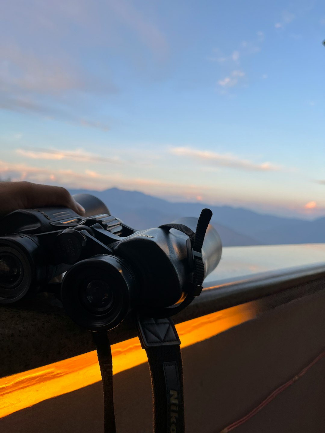 a person holding a camera on top of a ledge travel vlogging camera setup mountain view