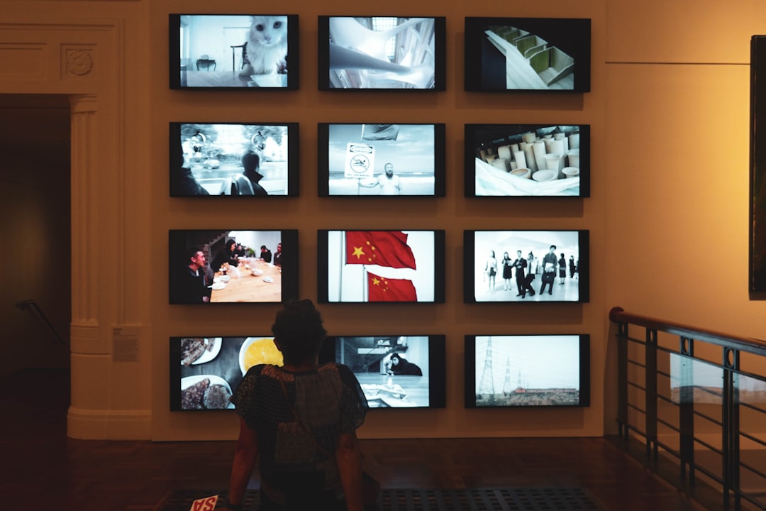 a person sitting in front of a wall of televisions smart tv streaming data privacy collection