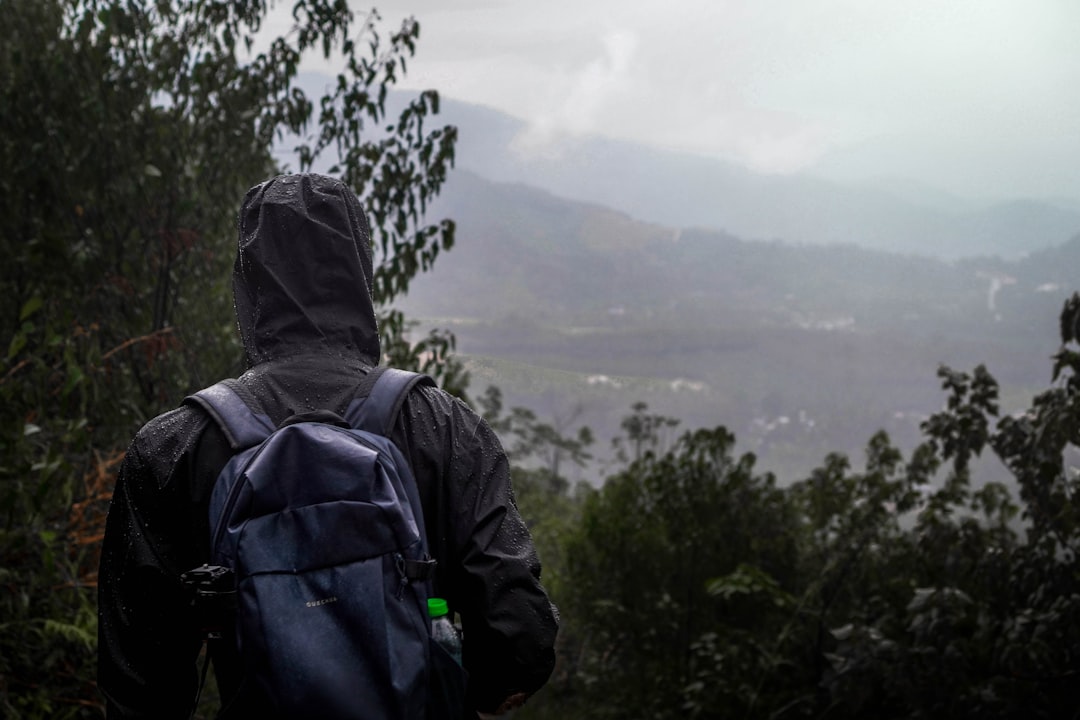 a person with a backpack walking up a hill travel vlogging camera setup mountain view