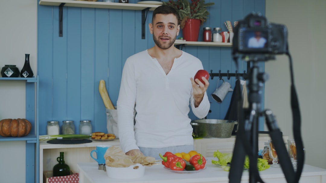 man holding apple in kitchen recording video food video cooking tutorial youtube recipe kitchen video