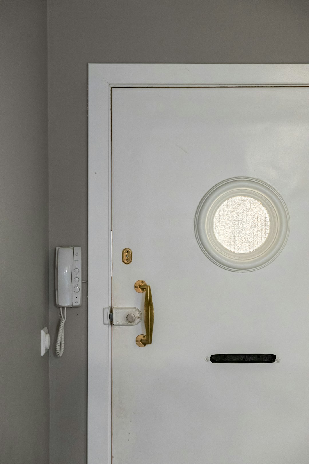 a white door with a round window in a room smart home door lock user access control mobile app lock