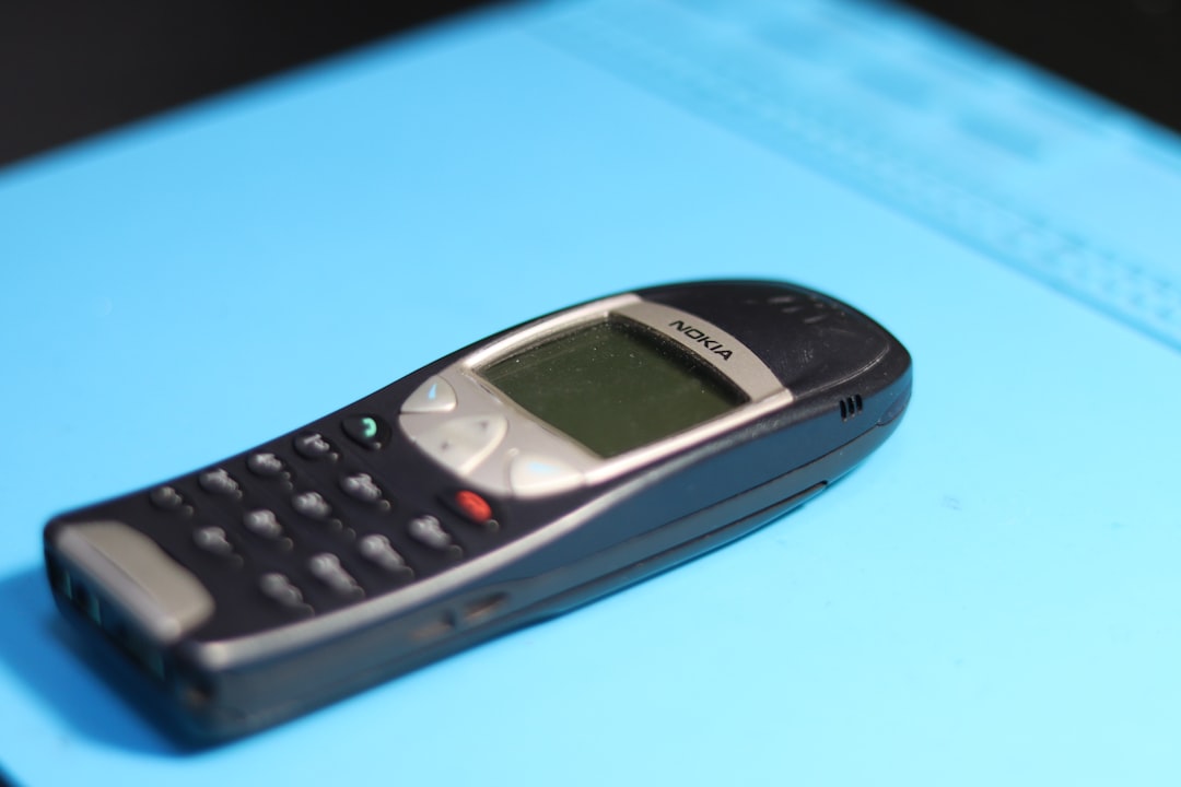 an old nokia phone is on a blue surface low budget smartphone outdated phone features entry level user