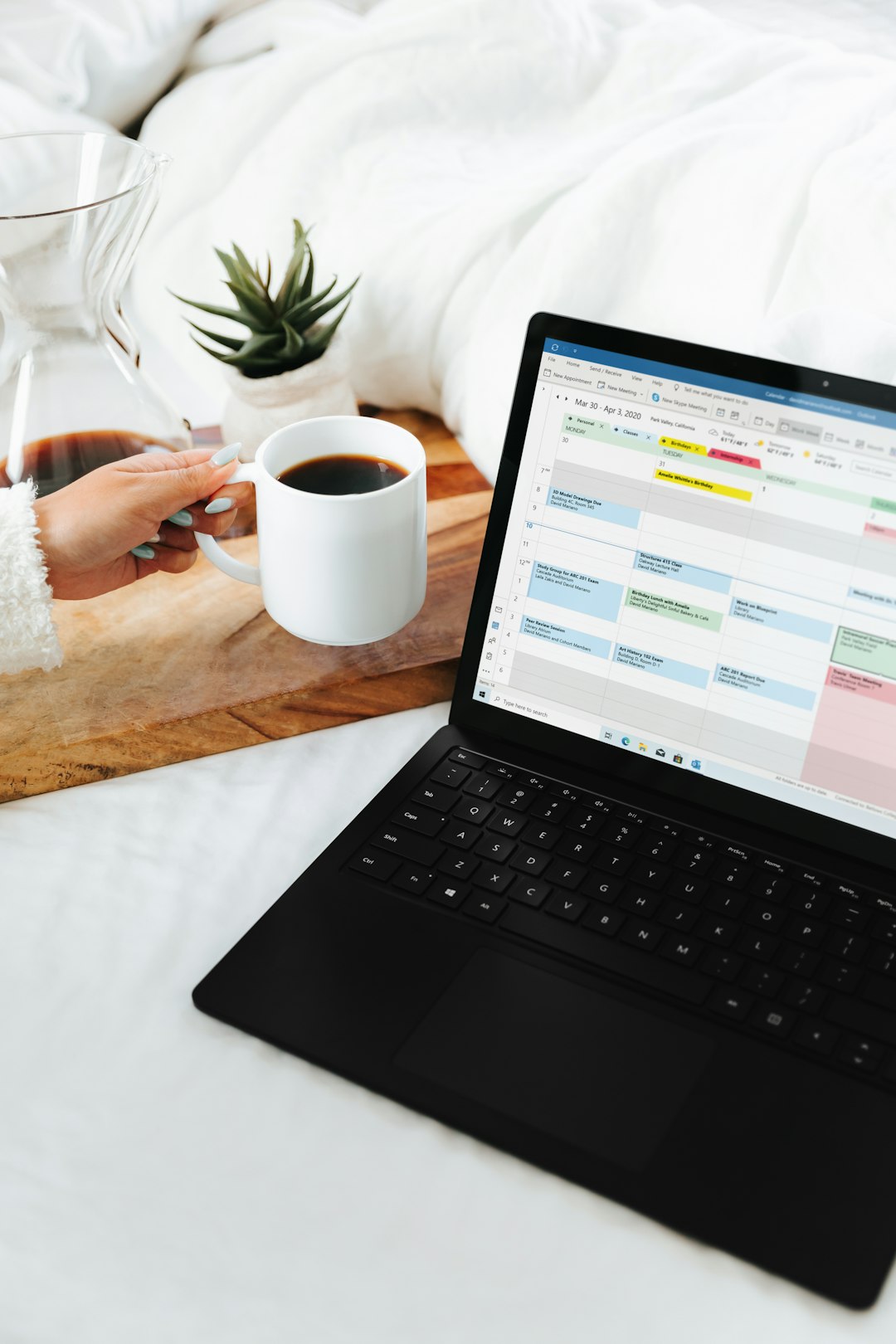 person holding white ceramic mug in front of black microsoft surface laptop computer wordpress plugin dashboard vacation rental booking calendar integration