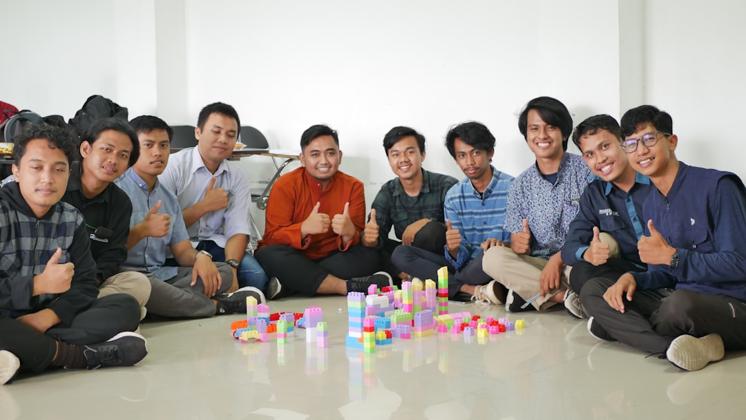 a group of men sitting next to each other team meeting mentor apprentice modern workspace