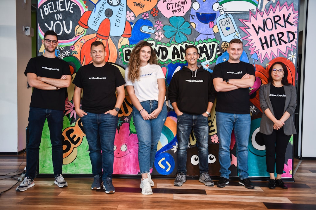 a group of people standing in front of a colorful wall group photo startup founders networking event