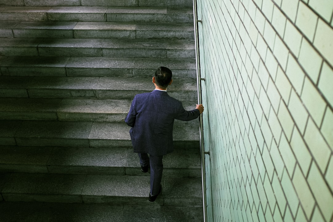 a man in a suit walking up a flight of stairs business failure challenges tough decisions