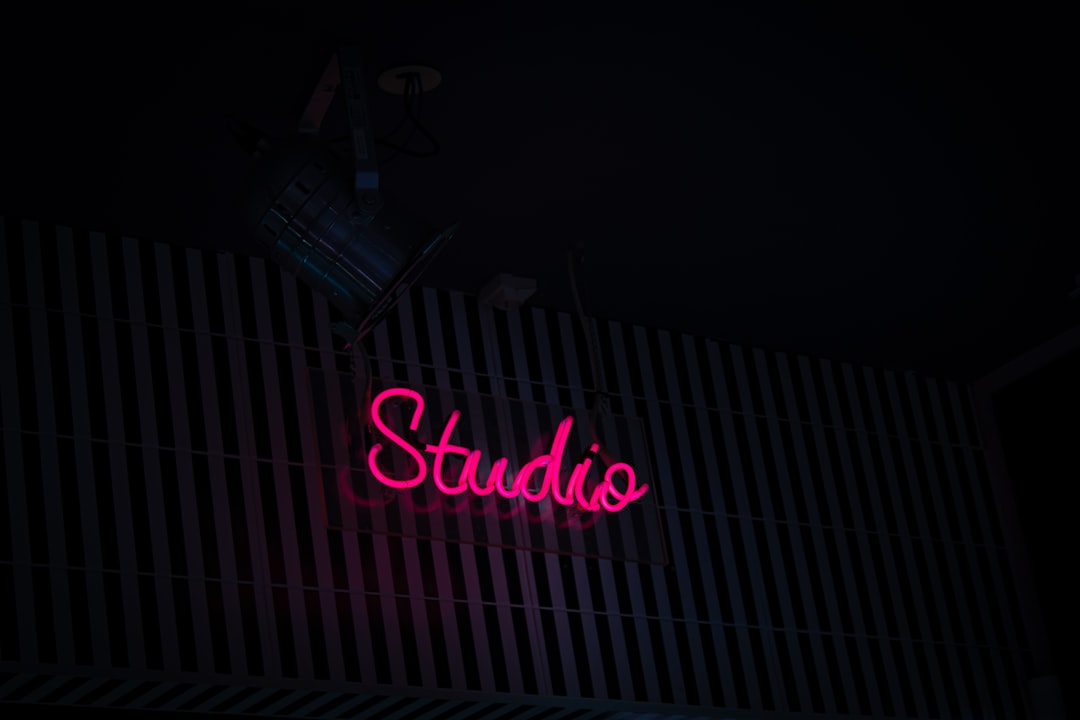 a neon sign that reads studio on the side of a building indie game development small studio creative workspace